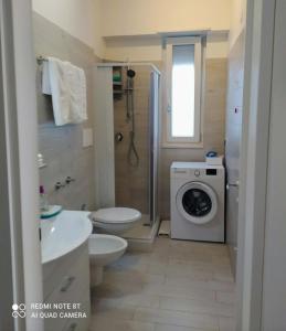 a bathroom with a toilet and a washing machine at Casa DOLCE PUGLIA Melograno in Castellana Grotte