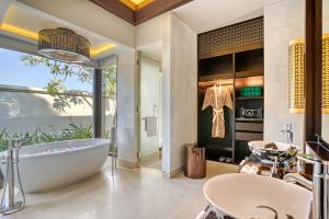 a bathroom with a tub and a sink at Banyan Tree Lang Co in Hue