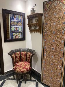 a chair sitting next to a wall with a door at Dar Bouzoubaa in Fez