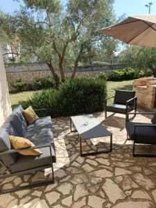 a patio with two couches and an umbrella at Kuća za odmor in Brzac