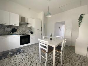 eine weiße Küche mit einem weißen Tisch und Stühlen in der Unterkunft Casa Matilde & Aurora con giardino e posto auto privato in Sirolo