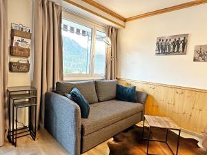 a living room with a couch and a window at 45m2 Alpenschick mit Ausblick - Pool - 2P. - E405 in St. Moritz