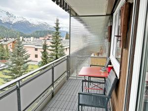 a balcony with a table and a view of the mountains at 41m2 Alpenschick mit Ausblick - Pool - 2P - E405 in St. Moritz