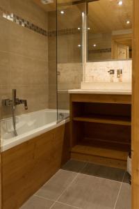 een badkamer met een bad en een wastafel bij Résidence Koh-I Nor by Les Etincelles in Val Thorens