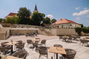 patio ze stołami i krzesłami oraz budynek w obiekcie Andrássy Kúria & Spa w mieście Tarcal