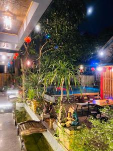 - une cour avec des bancs et une piscine la nuit dans l'établissement Asahi Villa Tam Coc, à Ninh Binh