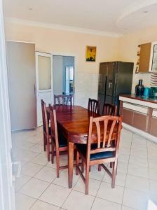 a kitchen with a wooden dining table and chairs at B&B/chambres d'hôtes in Antananarivo