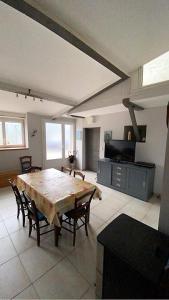 een grote woonkamer met een tafel en stoelen bij Maison de famille rustique et rénovée Chez Mouichou in Gestiès