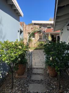 a stone walkway with potted plants in front of a building at Home From Home, Waverley B&B, Johannesburg in Johannesburg