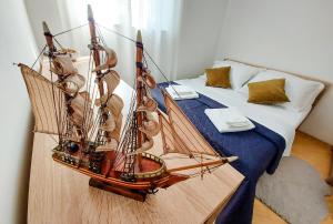a wooden model of a boat sitting on a bed at Kuća za odmor in Brzac
