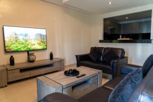 ein Wohnzimmer mit Sofas und einem Flachbild-TV in der Unterkunft Intimate Apartment with a beautiful view in Tangier