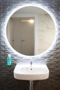 uma casa de banho com um lavatório branco e um espelho. em Presidente em Granada
