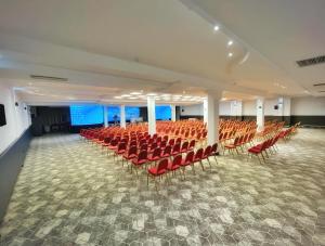 an empty hall with red chairs in a room at Hotel Metropol – Metropol Lake Resort in Ohrid +44 photos