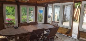a dining room with a wooden table and chairs at T4 climatisé à 20 mn de Disney et 50 de Paris dans jolie maison briarde in Mortcerf