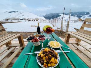 a picnic table with plates of food and a bottle of wine at Altay Village Hotel in Orto-Saz +24 photos