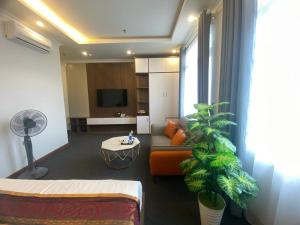 uma sala de estar com um sofá e uma planta em Win Villa Hotel & Apartment em Hanói