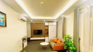 a living room with a couch and a tv at Win Villa Hotel & Apartment in Hanoi