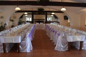 eine Reihe von Tischen mit weißen Tischdecken und lila Bogen in der Unterkunft Bison Ranch in Rožnov