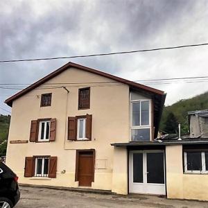 Gestiès的住宿－Maison de famille rustique et rénovée Chez Mouichou，白色的房子,设有棕色的门和窗户
