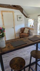 een woonkamer met een tafel en 2 krukken bij Romantic Hideaway in Trawsfynydd