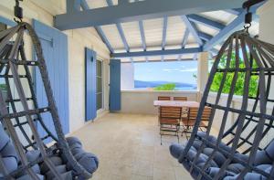a porch with two swings and a table at Rooms Salvia in Cres