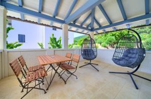 a patio with chairs and a table and swings at Rooms Salvia in Cres