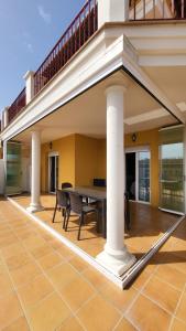 a patio with a table and a balcony at TERRASOL AZUCARERA ATICO LUJO in Torre del Mar
