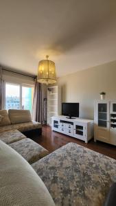 a living room with a couch and a flat screen tv at TERRASOL AZUCARERA ATICO LUJO in Torre del Mar +14 photos