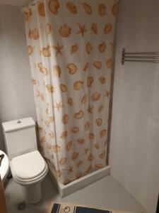 baño con aseo y cortina de ducha con conchas en Maisonette Basilissa, en Nea Potidaea