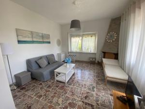 ein Wohnzimmer mit einem Sofa und einem Tisch in der Unterkunft Casa Matilde & Aurora con giardino e posto auto privato in Sirolo