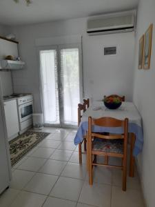 a kitchen with a table and chairs and a kitchen with a stove at Maisonette Basilissa in Nea Potidaea