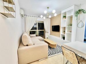 - un salon avec un canapé et une table dans l'établissement Bonito apartamento en la playa, à Benicàssim
