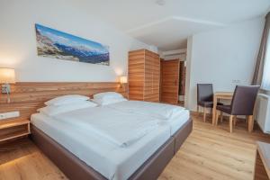 sypialnia z łóżkiem, stołem i krzesłami w obiekcie Hotel Gesser w mieście Sillian