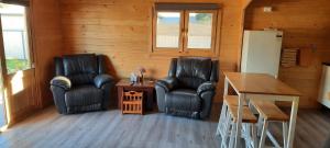 2 schwarze Ledersessel und ein Tisch in einem Zimmer in der Unterkunft Churchill Cabin in Maryborough
