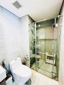 uma casa de banho com um WC e uma cabina de duche em vidro. em Siro House- Homestay cao cấp Vinhomes Ocean Park, Gia Lâm em Hanói