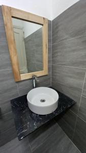 baño con lavabo y espejo en la encimera en 2H Homestay, en Thôn Lại Thê