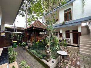 a garden with a statue in front of a building at Brata Inn Ubud in Ubud