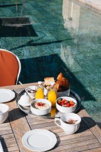 a table with breakfast foods and drinks on a table near a pool at Le Château Réal in Saint-Seurin-de-Cadourne