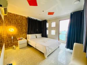 - une chambre avec un lit et une grande fenêtre dans l'établissement Jewel Hotel, à Hô-Chi-Minh-Ville