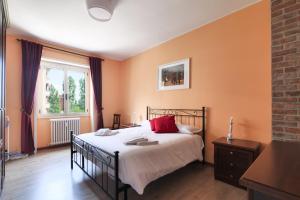 米蘭的住宿－Mila Apartments Brizi，一间卧室拥有橙色的墙壁,配有一张带红色枕头的床。