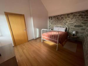 a bedroom with a bed and a stone wall at Casa Rustica da Maloeira in Malseira