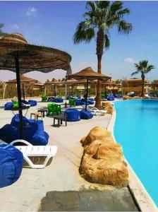 a resort with a pool with chairs and umbrellas at قريه لاسرينا العين السخنة in Ain Sokhna