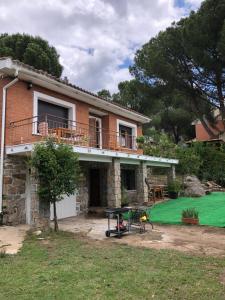 een stenen huis met een patio en een tafel bij Casa Rural Pantano de San Juan in Pelayos de la Presa