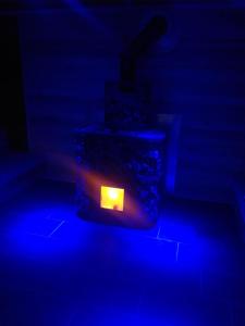 ein dunkles Zimmer mit einer Kerze in blauem Licht in der Unterkunft Sauna Fifty Rekreációs Szaunapark in Vaszar
