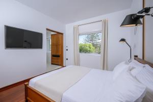 Un dormitorio blanco con una cama grande y una ventana en BlueGreen Villa, en Karteros
