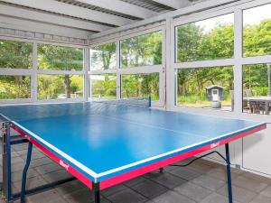 una mesa de ping pong en una habitación con ventanas en 19 person holiday home in L gst r, en Trend