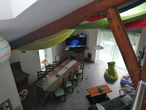ein Wohnzimmer mit einem Holztisch und einem TV in der Unterkunft Gîte Les Mille Pauses in Fresse