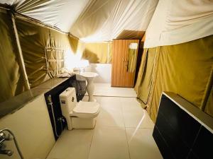 a bathroom with a toilet and a sink in a tent at Jungle Journey- A Lake Resort in Kumbhalgarh