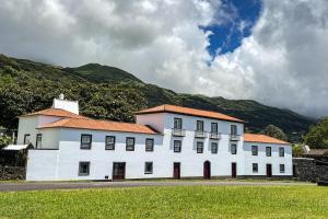 duży biały budynek z górą w tle w obiekcie Quinta dos Mistérios- Turismo de Habitação w mieście Fajã de Santo Amaro