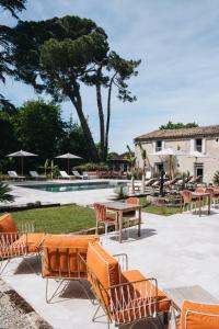 a group of chairs and tables next to a pool at Le Château Réal in Saint-Seurin-de-Cadourne